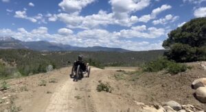 An adaptive athlete riding a three-wheeled bike and enjoying one of the many trails at Durango Mesa Park.